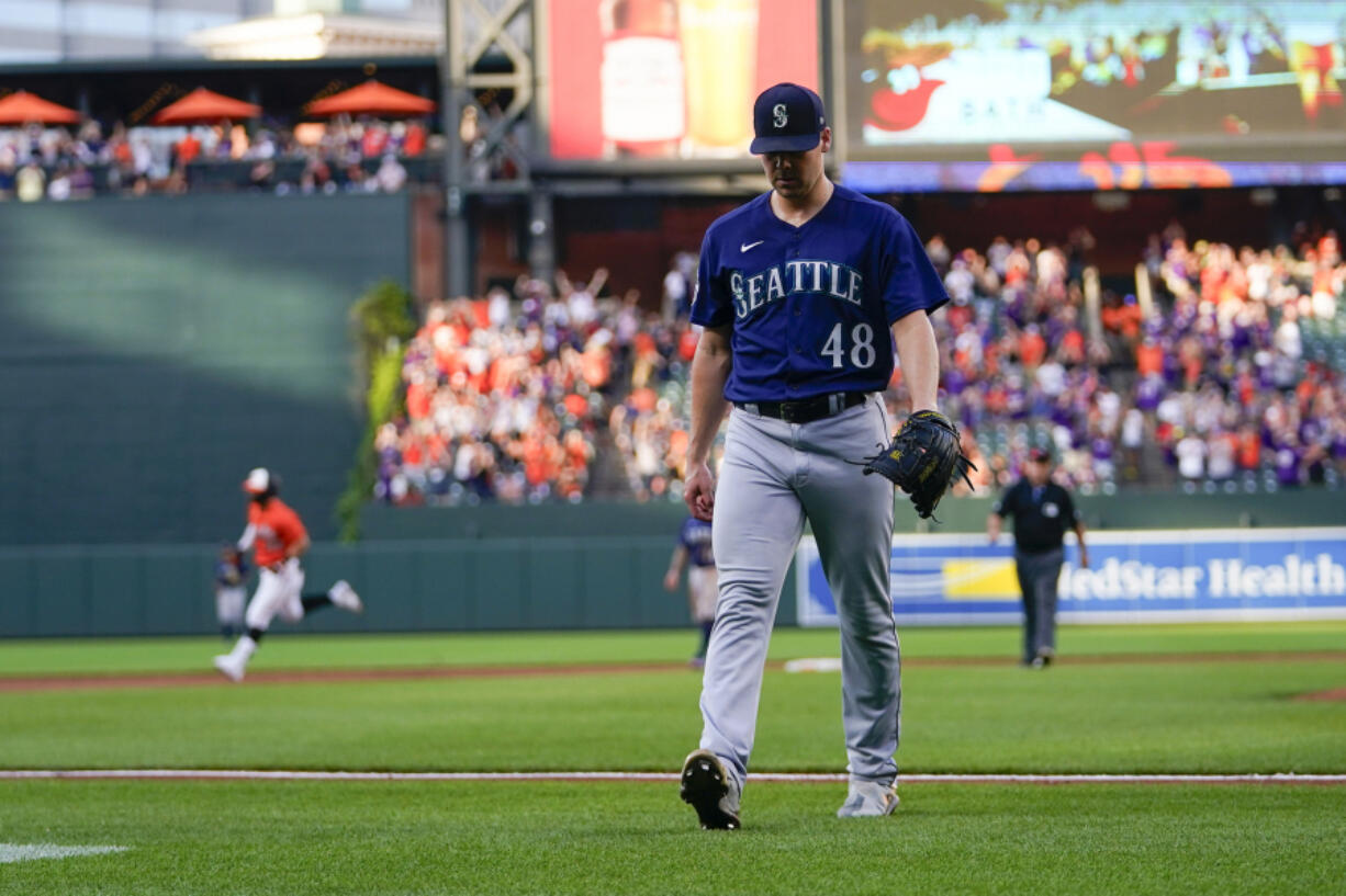 Seattle Mariners relief pitcher Justin Topa (48) heads to the clubhouse as Baltimore Orioles' Ryan McKenna, back left, runs the bases after hitting a two-run walkoff home run off him in the 10th inning of a baseball game, Saturday, June 24, 2023, in Baltimore. The Orioles won 6-4.