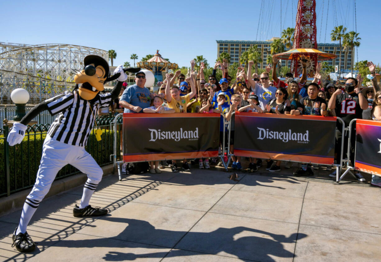 Goofy, left, rallies the crowd gathered to watch ESPN broadcast a Super Bowl preview show from Disney California Adventure in Anaheim, California on Thursday, Feb. 10, 2022.