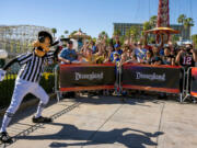 Goofy, left, rallies the crowd gathered to watch ESPN broadcast a Super Bowl preview show from Disney California Adventure in Anaheim, California on Thursday, Feb. 10, 2022.