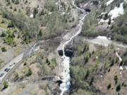 A Washington State Department of Transportation engineering geologist studies the head of the landslide that buried Highway 504 some 2,000 feet below.