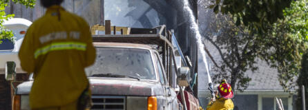 A Vancouver firefighter sprays the outside of a burned building Monday, June 5, 2023, on Northeast 68th Avenue in Vancouver. .