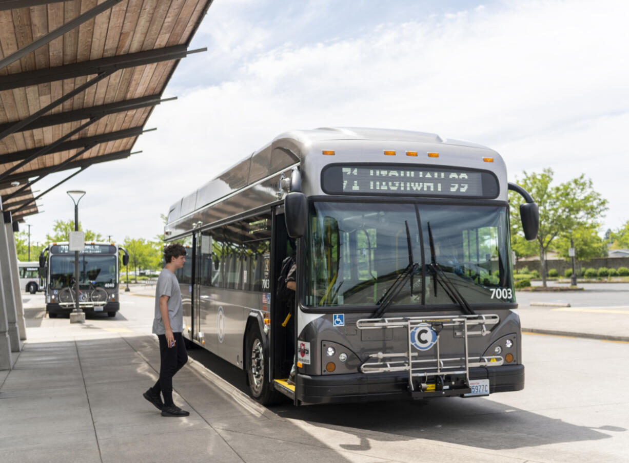 Commuters step onto a new fully electric C-Tran bus on Wednesday at the 99th Street Transit Center in Vancouver. The transit agency has nine of the buses on the street, with another idled due to a software problem.