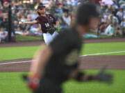 Raptors third baseman Jake Tsukada, left, tosses a ground ball to first base Tuesday, June 27, 2023, during the Raptors’ game against Bend at the Ridgefield Outdoor Recreation Complex.