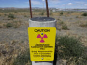 In this photo taken July 11, 2016, a sign warns of radioactive material stored underground on the Hanford Nuclear Reservation near Richland.