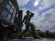 The sun shines through a break in the clouds, Wednesday, June 30, 2021, above the statue of Seattle Mariners Hall-of-Famer Ken Griffey Jr. at T-Mobile Park in Seattle. Temperatures cooled considerably in western Washington, Oregon and British Columbia Wednesday after several days of record-breaking heat, but the interior regions of the region were still sweating through triple-digit temperatures as the weather system moved east. (AP Photo/Ted S.