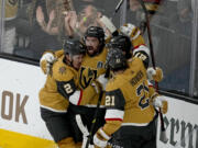 Vegas Golden Knights right wing Mark Stone, left, celebrates his goal against the Florida Panthers with Brett Howden (21), defenseman Zach Whitecloud (2) and center Chandler Stephenson during the third period of Game 1 of the NHL hockey Stanley Cup Finals, Saturday, June 3, 2023, in Las Vegas.