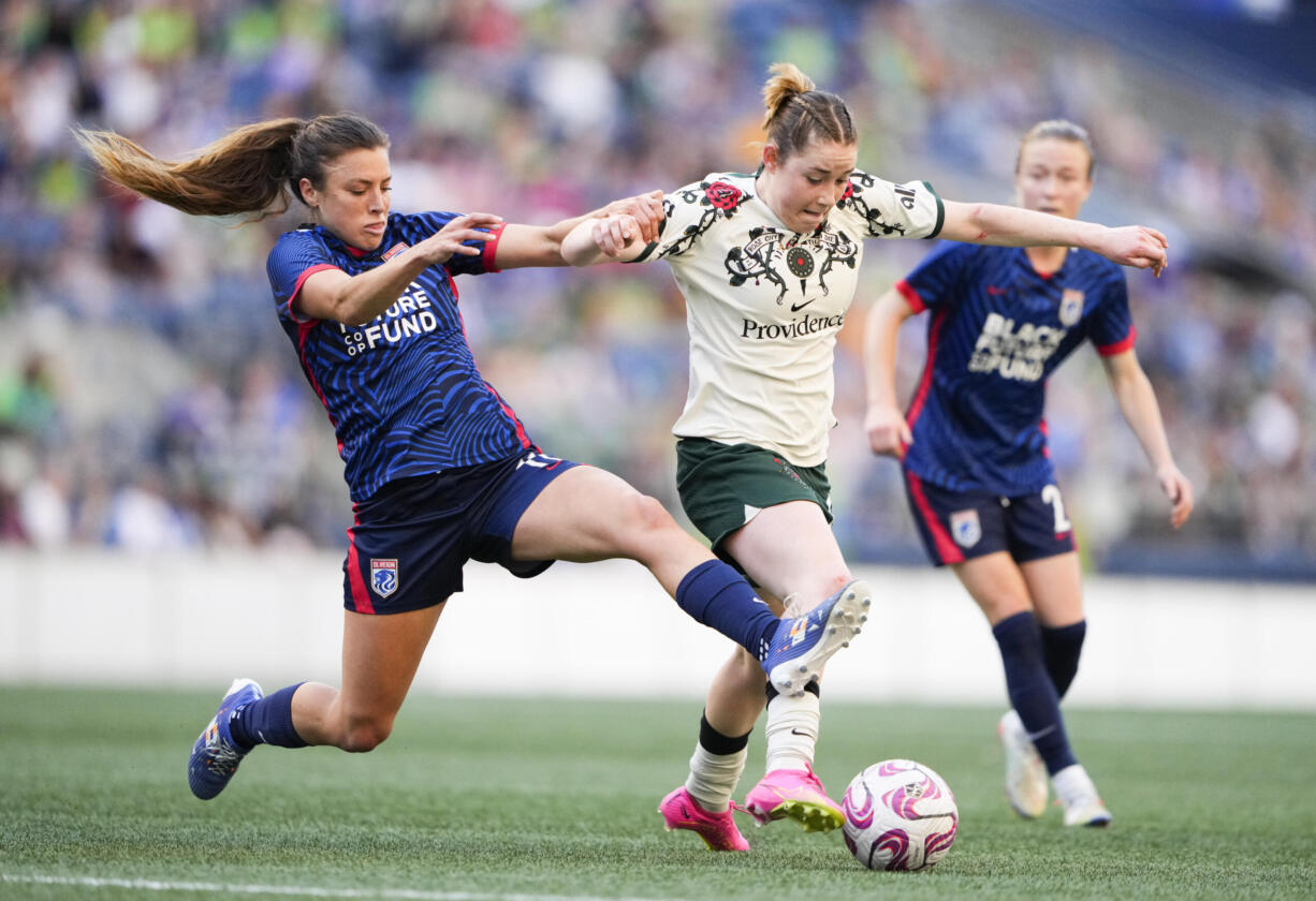 OL Reign defender Sofia Huerta, left, fouls Portland Thorns midfielder Olivia Moultrie, center, during the first half of an NWSL soccer match, Saturday, June 3, 2023, in Seattle.