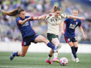 OL Reign defender Sofia Huerta, left, fouls Portland Thorns midfielder Olivia Moultrie, center, during the first half of an NWSL soccer match, Saturday, June 3, 2023, in Seattle.