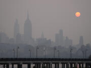 The sun rises over a hazy New York City skyline as seen from Jersey City, N.J., Wednesday, June 7, 2023. Intense Canadian wildfires are blanketing the northeastern U.S. in a dystopian haze, turning the air acrid, the sky yellowish gray and prompting warnings for vulnerable populations to stay inside.