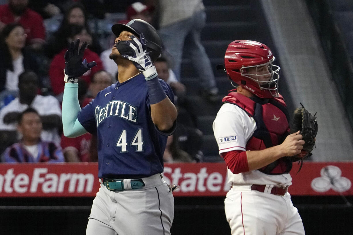 Seattle Mariners' Julio Rodriguez, left, celebrates after hitting a two-run home run as Los Angeles Angels catcher Matt Thaiss stands at the plate during the third inning of a baseball game Saturday, June 10, 2023, in Anaheim, Calif. (AP Photo/Mark J.