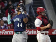 Seattle Mariners' Julio Rodriguez, left, celebrates after hitting a two-run home run as Los Angeles Angels catcher Matt Thaiss stands at the plate during the third inning of a baseball game Saturday, June 10, 2023, in Anaheim, Calif. (AP Photo/Mark J.