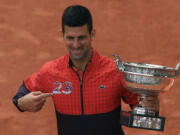 Serbia's Novak Djokovic holds the trophy as he celebrates winning the men's singles final match of the French Open tennis tournament against Norway's Casper Ruud in three sets, 7-6, (7-1), 6-3, 7-5, at the Roland Garros stadium in Paris, Sunday, June 11, 2023. Djokovic won his record 23rd Grand Slam singles title, breaking a tie with Rafael Nadal for the most by a man.