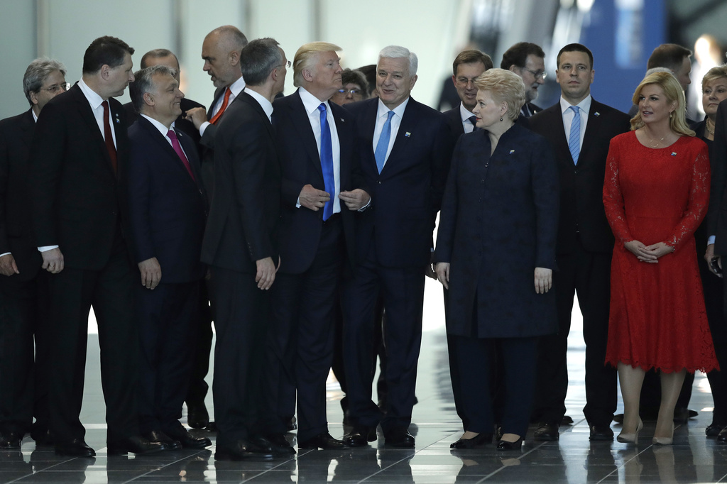 FILE - U.S. President Donald Trump, center, stands between Montenegro Prime Minister Dusko Markovic, center right, and NATO Secretary General Jens Stoltenberg, center left, during a NATO summit in Brussels Thursday, May 25, 2017. As Trump becomes the first former president to face federal charges that could put him in jail, many Europeans are watching the case closely. But hardly a single world leader has said a word recently about the man leading the race for the Republican party nomination.