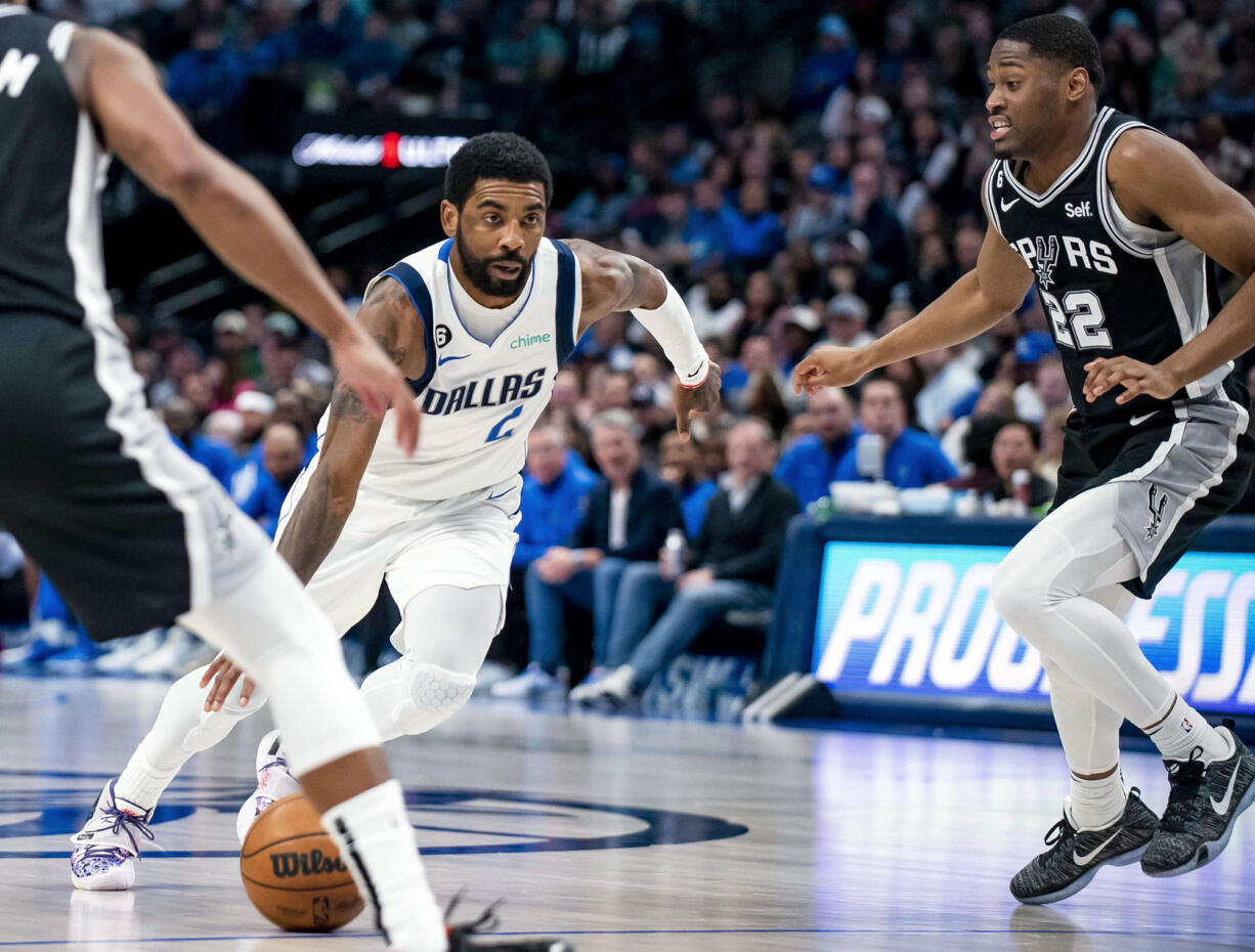 FILE - Dallas Mavericks guard Kyrie Irving (2) drives past San Antonio Spurs guard Malaki Branham (22) in the second half of an NBA basketball game Feb. 23, 2023, in Dallas. Irving agreed to stay with the Mavericks on a three-year, $126 million deal when free agency opened Friday, June 30, 2023. (AP Photo/Emil T.