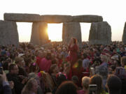 Revelers gather at the ancient stone circle Stonehenge to celebrate the Summer Solstice, the longest day of the year, near Salisbury, England, Wednesday, June 21, 2023. Druids, pagans, hippies, local residents, tourists and costumed witches and wizards have gathered around a prehistoric stone circle on a plain in southern England to express their devotion to the sun.