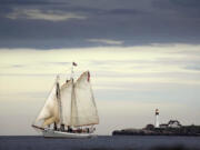 The schooner Timberwind cruises with her guests on a sunset sail off the coast of Cape Elizabeth, Maine, Thursday, June 8, 2023. Portland Head Light stands at the mouth of the harbor in the background. While much of the East Coast is dealing with the smoke from the Canadian wildfires, Maine has been enjoying clean air due to a low pressure system and favorable winds. (AP Photo/Robert F.