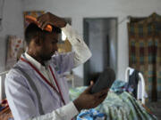 Jitendra Kumar, a paramedic who travels in an ambulance, sweats while he gets ready for duty in a room he shares with several others at the district government hospital quarters, in Banpur in the Indian state of Uttar Pradesh, Sunday, June 18, 2023. Ambulance drivers and other healthcare workers in rural India are the first line of care for those affected by extreme heat.