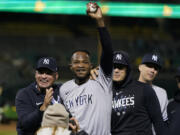 New York Yankees' Domingo Germán, center, celebrates after pitching a perfect game against the Oakland Athletics during a baseball game in Oakland, Calif., Wednesday, June 28, 2023. The Yankees won 11-0. (AP Photo/Godofredo A.