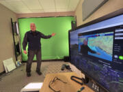 In this June 21, 2023, photo, meteorologist David Percy films the daily "Alaska Weather" program in a makeshift studio at the National Weather Service office in Anchorage, Alaska. The "Alaska Weather" program she oversees, the only weather show produced by the National Weather Service, will have its last on-air broadcast Friday after Alaska Public Media dropped distribution, forcing it to YouTube.