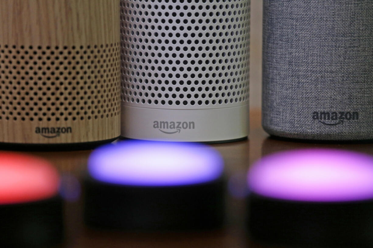 FILE - Amazon Echo and Echo Plus devices, behind, sit near illuminated Echo Button devices during an event by the company in Seattle, Sept. 27, 2017. In a vote Wednesday, May 31, 2023, the Federal Trade Commission is ordering Amazon to pay more than $30 million in fines over privacy violations involving its voice assistant Alexa and its doorbell camera Ring.