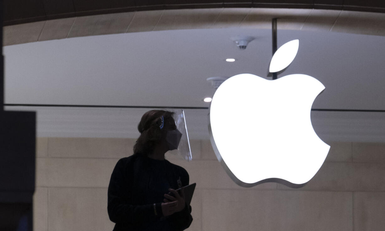 FILE - An Apple store employee stands inside the store in New York on Feb. 5, 2021. Apple illegally subjected employees to "coercive" interviews and interfered with the distribution of union leaflets at a New York City Apple Store, a U.S. labor board judge ruled Tuesday, June 20, 2023.