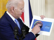 President Joe Biden holds a paper showing an air quality level for Washington as he speaks about Canada's wildfires during a news conference Thursday in the East Room of the White House in Washington.