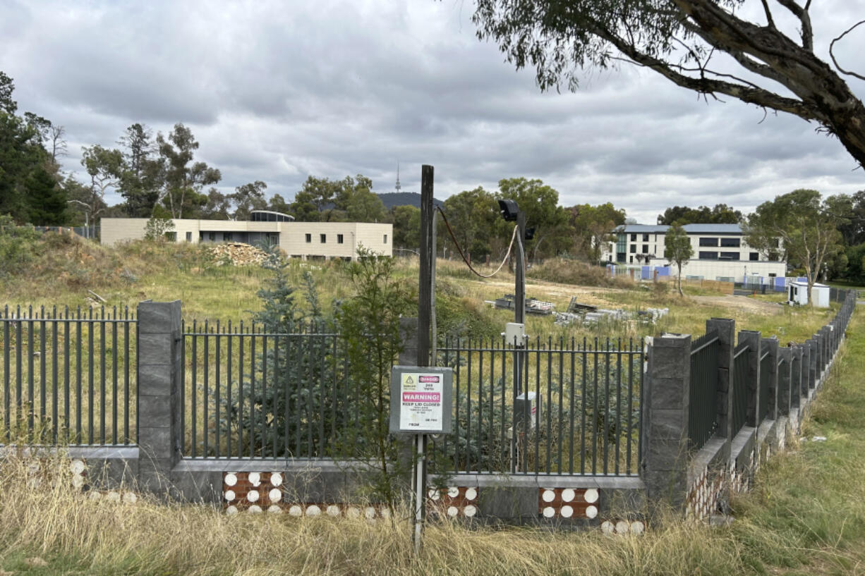 THIS CORRECTS THE PHOTOGRAPHER'S NAME TO MCGUIRK - An unoccupied building, left, sits on the grounds of a proposed new Russian embassy, across from another building, right, that is part of the Chinese embassy near the Australian Parliament in Canberra, Feb. 28, 2023. Australia's House of Representatives passed legislation Thursday, June 15, 2023, to prevent Russia from building a new embassy near Parliament House on security grounds.