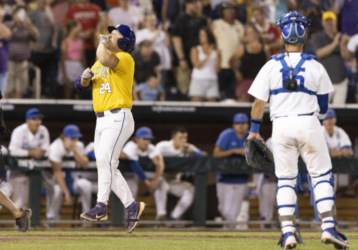 LSU's Cade Veloso (24) celebrates as he approaches home plate after hitting a solo home run to take the lead against Florida in the 11th inning of Game 1 of the NCAA College World Series baseball finals in Omaha, Neb., Saturday, June 24, 2023. (AP Photo/Rebecca S.