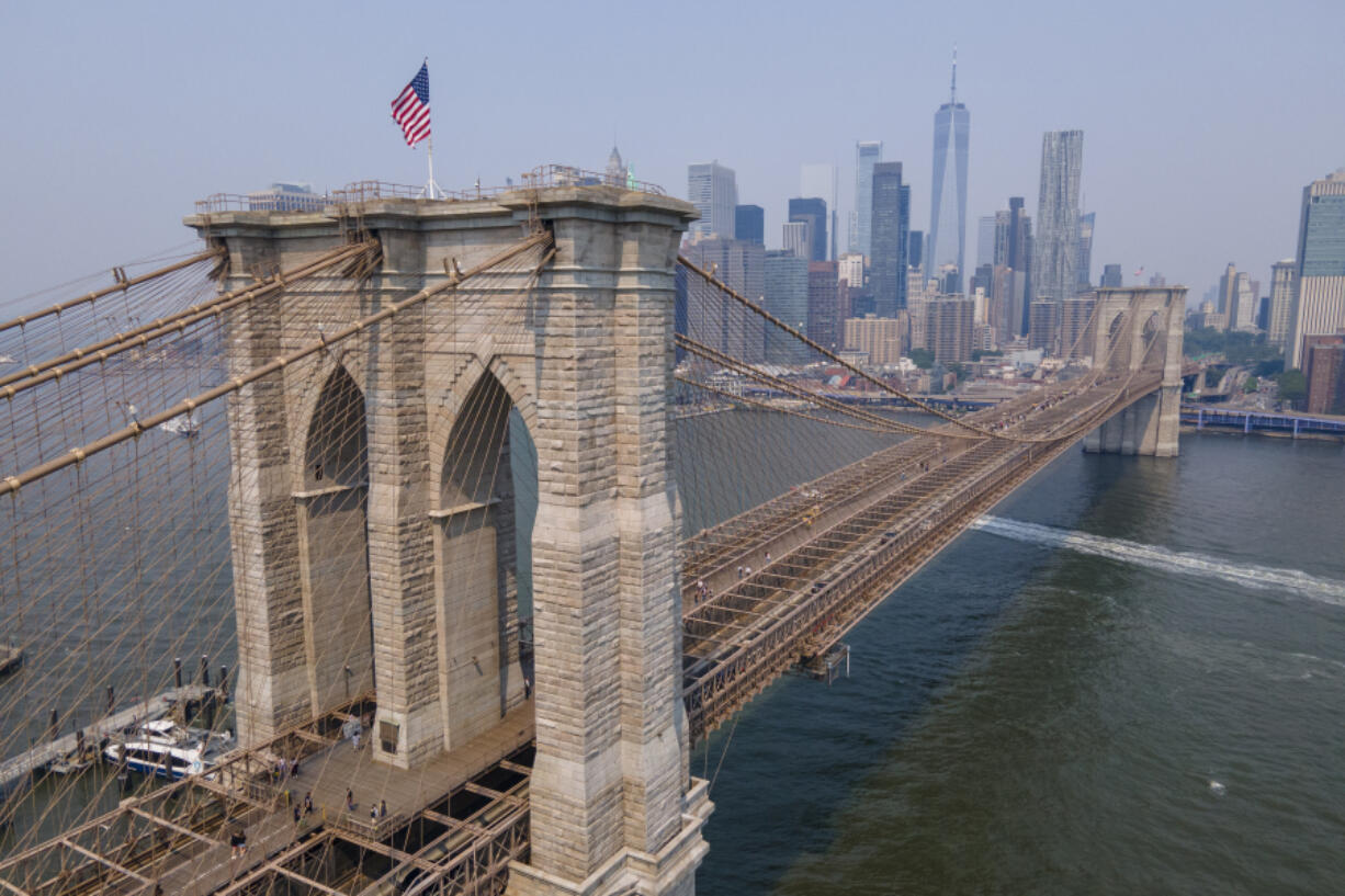 The Brooklyn Bridge, One World Trade Center and the lower Manhattan skyline are visible in New York on Thursday, June 8, 2023. With weather systems expected to hardly budge, the smoky blanket billowing across the U.S. and Canada from wildfires in Quebec and Nova Scotia should persist into Thursday and possibly the weekend.