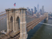 The Brooklyn Bridge, One World Trade Center and the lower Manhattan skyline are visible in New York on Thursday, June 8, 2023. With weather systems expected to hardly budge, the smoky blanket billowing across the U.S. and Canada from wildfires in Quebec and Nova Scotia should persist into Thursday and possibly the weekend.