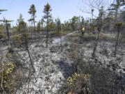 Department of Natural Resources and Renewables firefighters Walter Scott, left, and Zac Simpson work on a fire in Shelburne County, Nova Scotia onThursday, June 1, 2023.