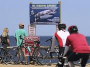 FILE - In this May 22, 2019, file photo, a shark warning warns beachgoers at Lecount Hollow Beach in Wellfleet, Mass. Scientists monitoring the white shark population in the waters off Cape Cod are stepping up their game by attaching more highly sophisticated sensors that include cameras to the predators to help keep beachgoers informed and safe, researchers said Tuesday, June 13, 2023.