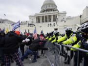 FILE - Rioters supporting President Donald Trump try to break through a police barrier at the Capitol in Washington, on Jan.