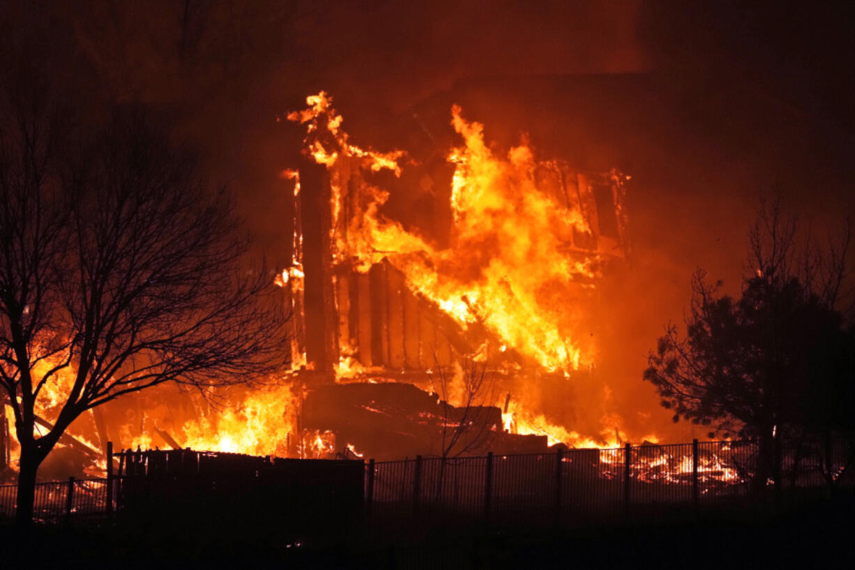 FILE - Homes burn as a wildfire rips through a development near Rock Creek Village, Dec. 30, 2021, near Broomfield, Colo. Authorities say they have wrapped up their investigation into what started the most destructive wildfire in Colorado history and will announce their findings on Thursday, June 8, 2023.