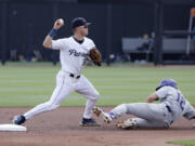 Dallas Baptist's Luke Hefner throws to first base after tagging out Washington's Cam Clayton during an NCAA baseball game on Friday, June 2, 2023, in Stillwater, Okla.