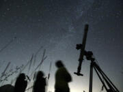 FILE - People look up to the sky at an observatory near the village of Avren east of the Bulgarian capital Sofia, Wednesday, Aug. 12, 2009. There's another chance to see five planets lined up in the sky, weather permitting. Saturn, Neptune, Jupiter, Uranus and Mercury will appear together before sunrise on Saturday., June 17, 2023. Jupiter and Saturn will be bright in the sky and easiest to see. Mercury will be the lowest to the horizon and harder to spot. And you'll need to break out binoculars or a telescope to find Neptune and Uranus.