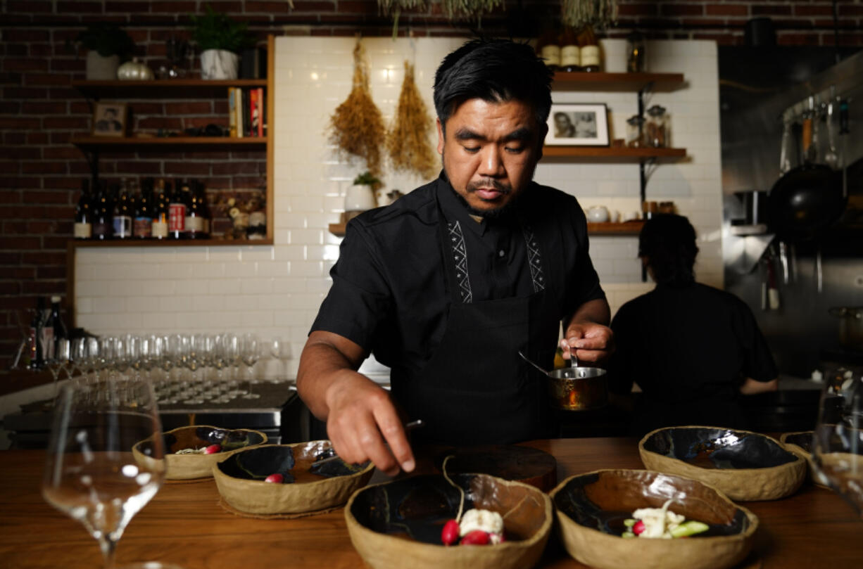 Chef Aaron Verzosa demonstrates plating Tailor Made, a course in which diners disclose their hunger level from five to one, at Filipino American restaurant Archipelago on May 24 in Seattle. Verzosa is nominated for a 2023 James Beard Award in the Best Chef: Northwest and Pacific category.