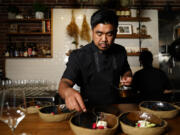 Chef Aaron Verzosa demonstrates plating Tailor Made, a course in which diners disclose their hunger level from five to one, at Filipino American restaurant Archipelago on May 24 in Seattle. Verzosa is nominated for a 2023 James Beard Award in the Best Chef: Northwest and Pacific category.