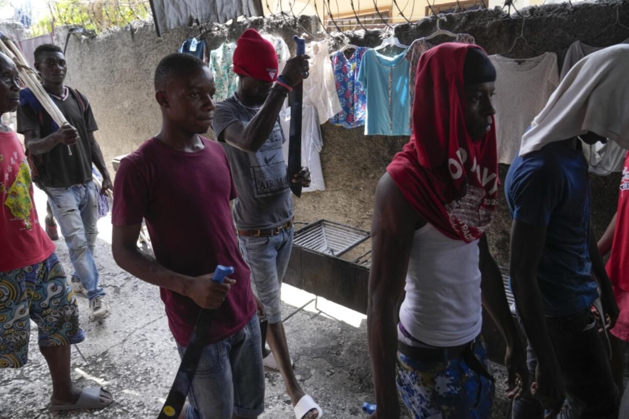 Men with machetes, part of "Bwa Kale," an initiative to resist gangs from getting control of their neighborhood, walk in the Delma district of Port-au-Prince, Haiti, Sunday, May 28, 2023.