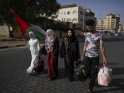 Huda Zaqqout, second left, walks with her relatives as she leaves Gaza City for the Hajj pilgrimage in Mecca, Saudi Arabia, Tuesday, June 13, 2023.