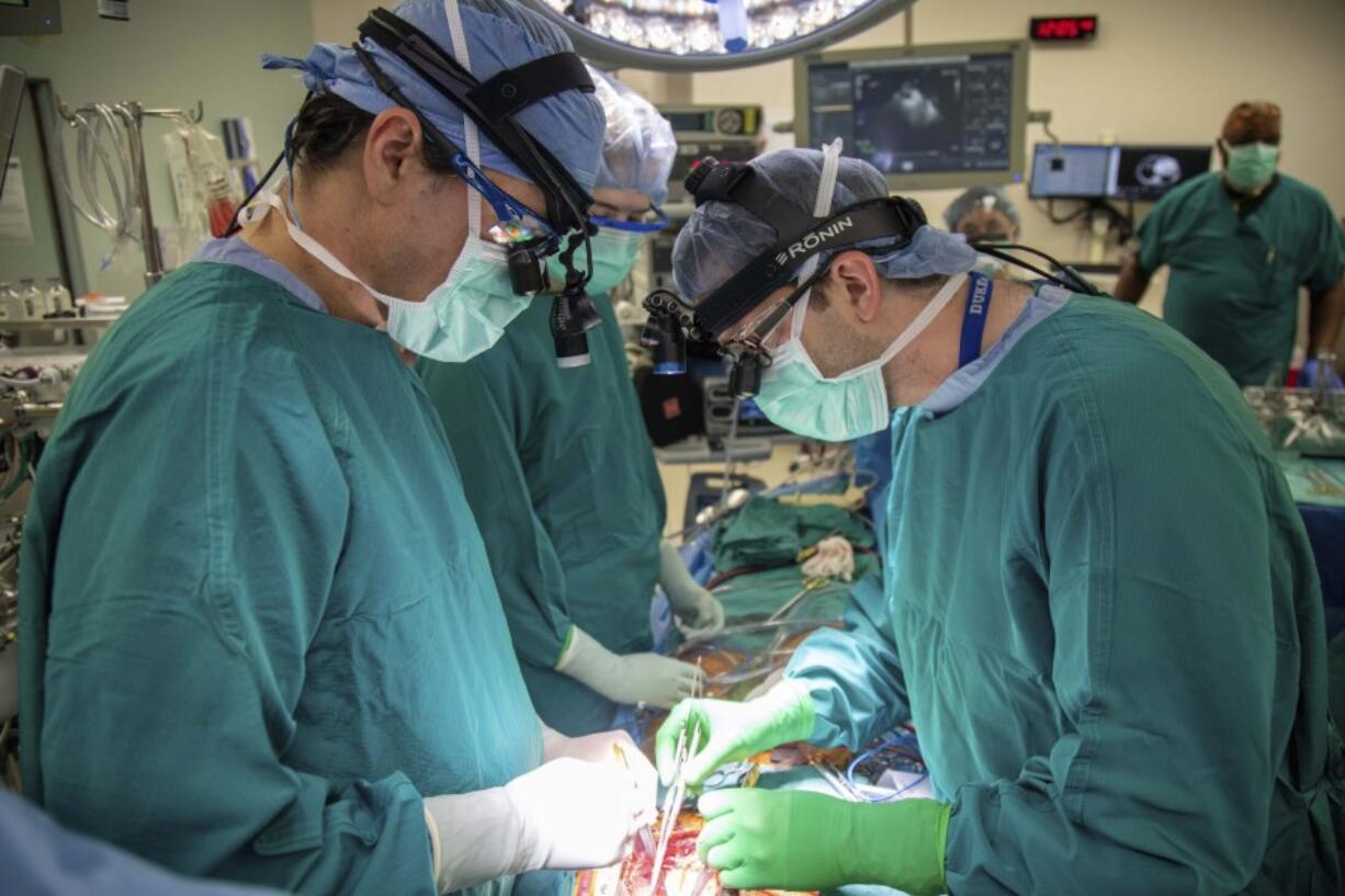 Surgeons Dr. Jacob Schroder, left, and Dr. Zachary Fitch perform a heart transplant at Duke University Hospital in Durham, N.C., in October 2022.