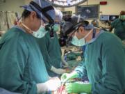 Surgeons Dr. Jacob Schroder, left, and Dr. Zachary Fitch perform a heart transplant at Duke University Hospital in Durham, N.C., in October 2022.