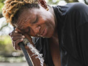 Judy Breland Morris cools off and washes herself off with a hose after she claims she was maced near Jackson Square, during an excessive heat warning in New Orleans, Tuesday, June 27, 2023.