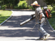 Gilmer Guinn blows off the driveway of a home on Central Avenue while wearing a hat to protect himself from the sun in Memphis, Tenn., on Thursday, June 29, 2023. As dangerous heat and humidity smothered parts of the South and Midwest on Thursday, local governments and charities worked to protect poor and elderly residents by opening cooling stations and delivering donated air conditioners.