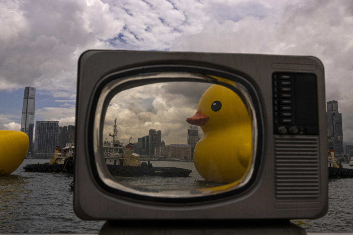 An art installation called "Double Ducks" by Dutch artist Florentijn Hofman is seen through a prop at Victoria Harbor in Hong Kong, Friday, June 9, 2023.