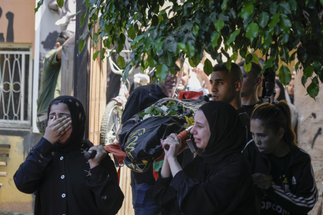 FILE - The classmates of 15-year-old Sadeel Naghniyeh carry her body during her funeral in the West Bank Jenin refugee camp Wednesday, June 21, 2023. The death of a 15-year-old girl who was killed by suspected Israeli fire during an Israeli military raid on June 19, is renewing scrutiny of Israel's record of causing civilian deaths during a more than yearlong crackdown on militants in the occupied West Bank.