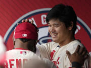 Los Angeles Angels' Shohei Ohtani, right, pats Luis Rengifo on the head prior to a baseball game against the Seattle Mariners Sunday, June 11, 2023, in Anaheim, Calif. (AP Photo/Mark J.