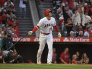 Los Angeles Angels' Shohei Ohtani drops his bat after hitting a two-run home run as Seattle Mariners catcher Cal Raleigh watches during the third inning of a baseball game Friday, June 9, 2023, in Anaheim, Calif. (AP Photo/Mark J.