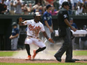 Baltimore Orioles' Jorge Mateo reacts after sliding to score on catcher Anthony Bemboom's double during the fifth inning of a baseball game against the Seattle Mariners, Sunday, June 25, 2023, in Baltimore.