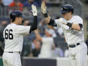 New York Yankees' Billy McKinney, right, celebrates with Kyle Higashioka (66) after hitting a solo home run off Seattle Mariners starting pitcher Luis Castillo in the fourth inning of a baseball game, Wednesday, June 21, 2023, in New York.